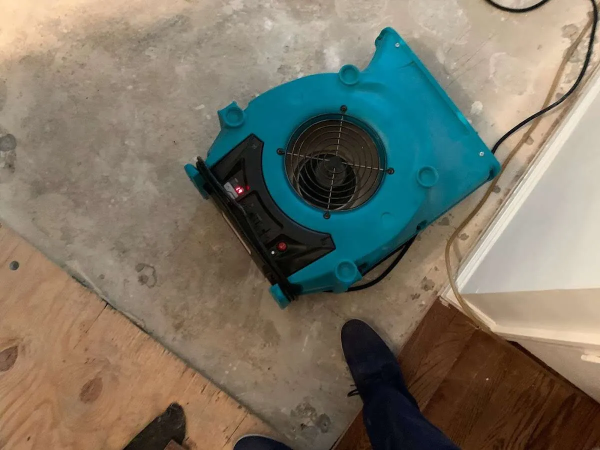 Air mover drying subfloor during Commercial Water Damage Restoration in Howell